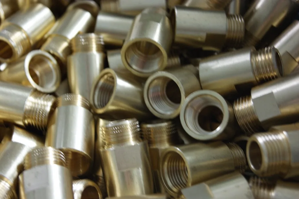 Schüttgut goldglänzend beschichteter Gewindehülsen und Fittings mit Innen- und Außengewinde